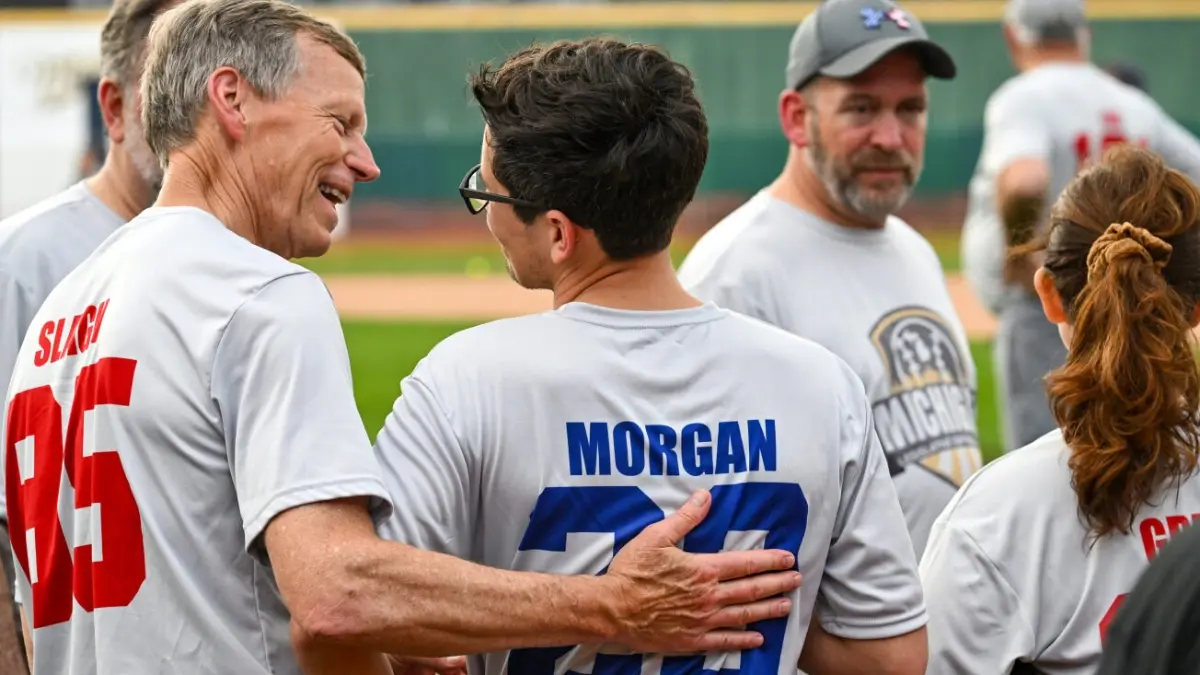 Bradley Slagh patting a young baseball player on the back on the field